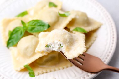 Peynirli ve fesleğenli lezzetli ravioli tam tabağa karşı, yakın plan.