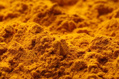 Aromatic turmeric powder as background, closeup view