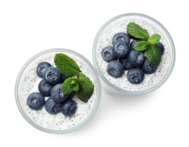 Yaban mersinli lezzetli chia pudingi ve nane şekeri beyaz bardakta izole edilmiş, üst manzara.