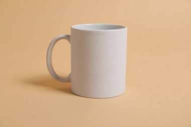 Bej arka planda damgalamak için boş beyaz bardak. Tasarım için model