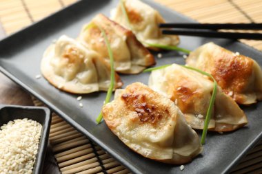 Lezzetli kızarmış gyoza hamur köfteleri. Masada susam tohumlarıyla servis ediliyor. Yakın plan.