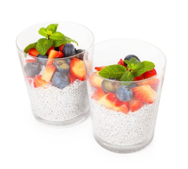 Çilekli Chia pudingi, yaban mersini ve naneli beyaz bardakta izole edilmiş nane.