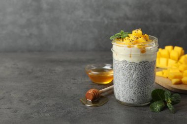 Bardakta mangolu lezzetli chia pudingi, gri desenli masada nane ve bal, metin için boşluk.