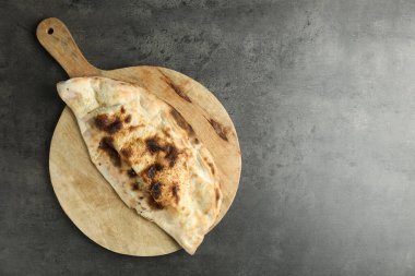 Gri desenli masa üzerinde nefis bir calzone, üst manzara. Metin için boşluk