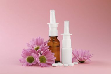 Alerji tedavisi. Farklı ilaçlar ve pembe arka planda çiçekler.