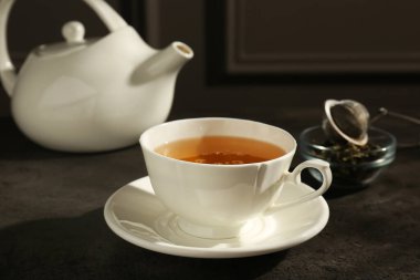 Koyu dokulu masada fincanda taze yeşil çay, yakın çekim.