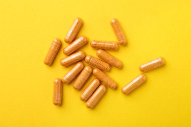 Sarı zemin üzerinde zerdeçal kapsülleri, düz yatıyordu