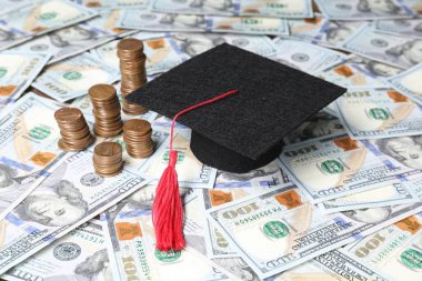 Mezuniyet şapkası ve bozuk paralar dolar banknotları, yakın plan. Okul taksiti