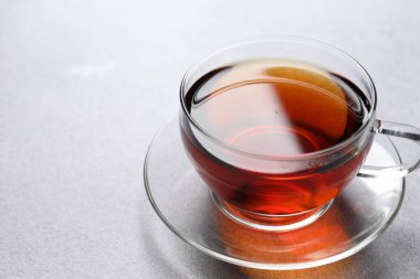 Aromatik siyah çay bardakta, aydınlık masada, yakın plan. Metin için boşluk
