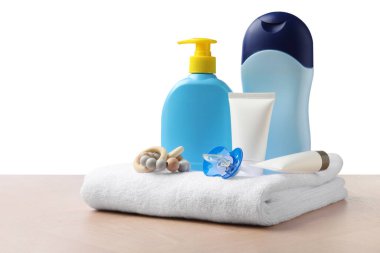 Bebek kozmetik ürünleri ve banyo aksesuarları beyaz arka plana karşı ahşap masa üzerinde
