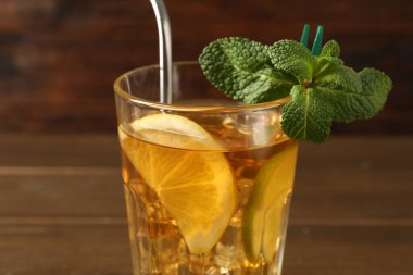 Buzlu çayı limon dilimleri, limon, nane ve bulanık arkaplanda pipet içerek tazeliyorum.