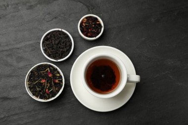 Aromatik çay ve kurumuş yapraklar siyah masanın üstünde, düz yatıyordu.