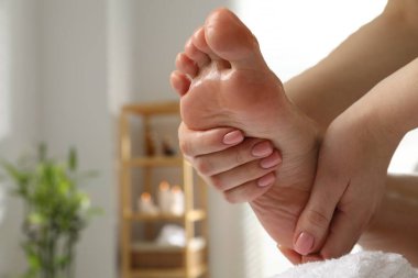 Kaplıca salonunda ayak masajı yaptıran bir kadın, yakın plan. Metin için boşluk