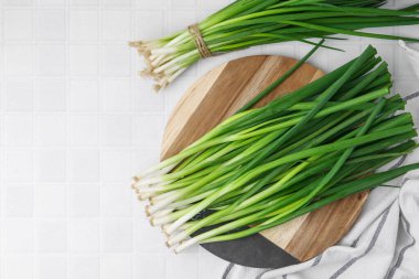 Beyaz fayanslı masada taze yeşil soğan, üst manzara. Metin için boşluk