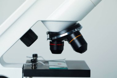 - Bilim. Açık gri arkaplanda cam kaydıraklı mikroskop, yakın plan