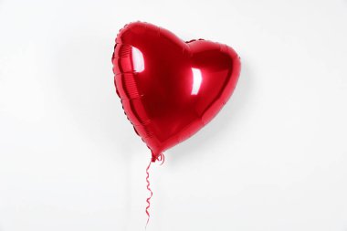 Beyaz arka planda kalp şeklinde bir kırmızı balon. Sevgililer Günü
