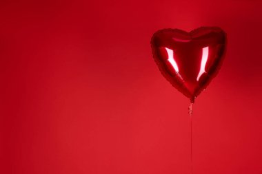 Kırmızı arka planda kalp şeklinde balon, mesaj için boşluk. Sevgililer Günü