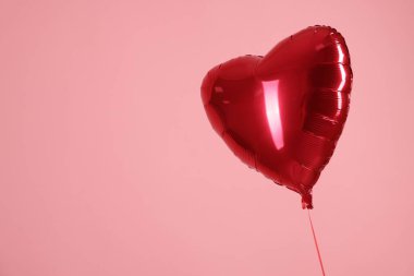 Pembe arka planda kırmızı bir kalp şeklinde balon, mesaj için yer var. Sevgililer Günün kutlu olsun.