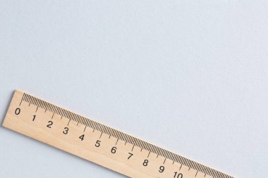 Açık gri arka planda tahta bir cetvel, üst manzara. Metin için boşluk