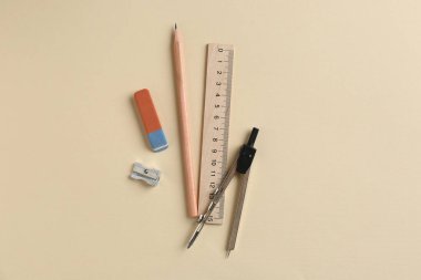 Bej arkaplan üzerinde cetvel ve diğer kırtasiye ile düz konum