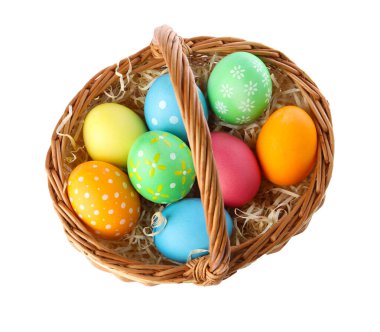 Mutlu Paskalyalar. Hasır sepetteki parlak renkli yumurtalar beyaza izole edilmiş.