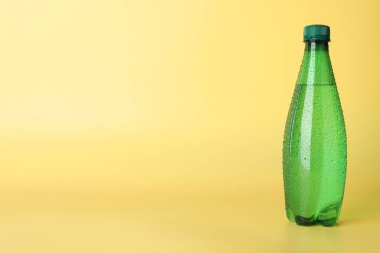 Sarı arka planda plastik su şişesi. Metin için boşluk