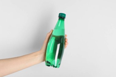 Arka planda plastik su şişesi tutan kadın, yakın plan.