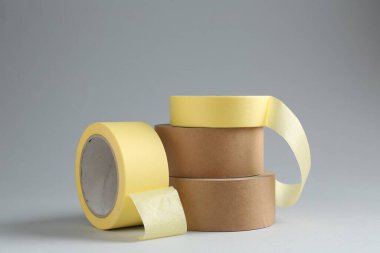 Gri arkaplanda farklı yapışkan bantların ruloları