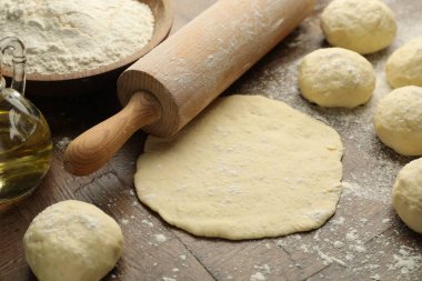 Taze hamur, merdane, un ve yağ ahşap masada, yakın plan.