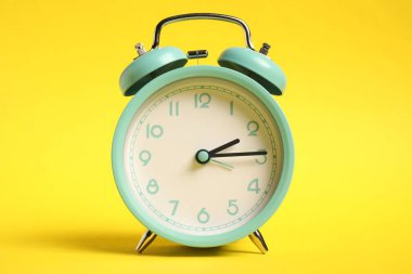 Sarı arka planda bir turkuaz alarm saati