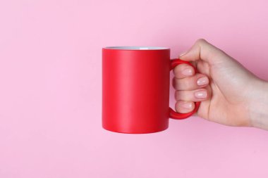 Pembe arka planda boş kırmızı bardak tutan kadın, yakın plan. Tasarım için model