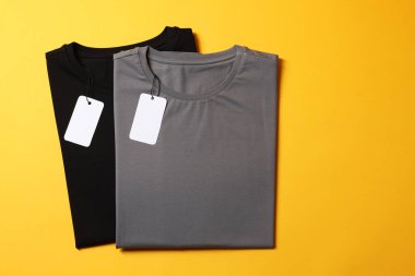 Sarı arka planda farklı boş tişörtler, üst manzara. Tasarım için model