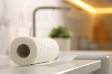 Mutfaktaki beyaz tezgahta kağıt havlu rulosu, yakın plan. Metin için boşluk