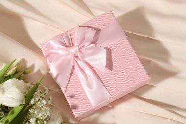 Güzel bir düğün hediyesi ve ipek kumaşta çiçekler, düz bir yatak.