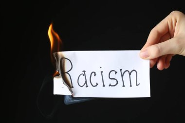 Siyah arka planda kelime ırkçılığı olan bir kadın, yakın plan.