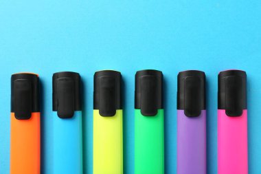 Açık mavi arkaplanda parlak ışıklandırıcılar, düz yatıyordu