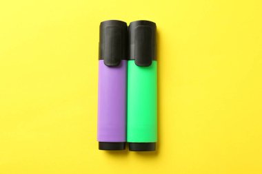 Sarı arkaplanda parlak fosforlu kalemler, düz yatış