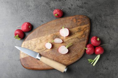 Cutting board with radishes and knife on grey table, flat lay clipart