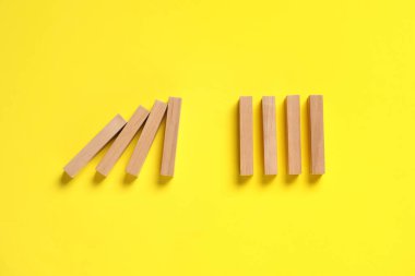 Domino etkisi. Sarı zemin üzerinde tahta bloklar, düz yatıyordu.