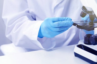 Laboratuvarda mikroskopla çalışan bilim adamı, yakın plan.