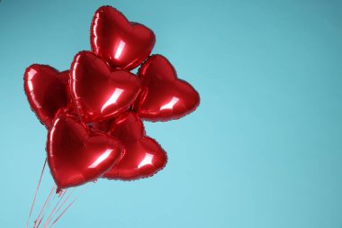Açık mavi arka planda bir sürü kırmızı kalp şeklinde balon, yazı için boşluk. Sevgililer Günün kutlu olsun.