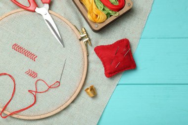 Nakış. Nakış. Çapraz dikişli tuval ve turkuaz ahşap masa üzerine malzeme, düz yatıyordu.