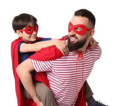 Baba ve oğlu beyaz arka planda süper kahraman kostümleri giyiyorlar.