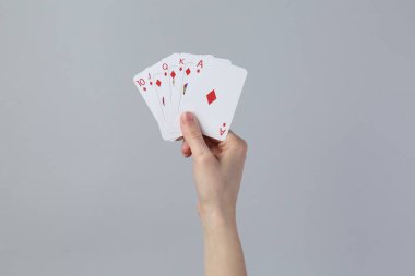Gri arkaplanda kart oynayan kadın, yakın plan