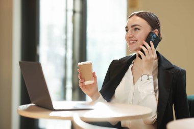 Masada çalışan şık takım elbiseli bir kadın.