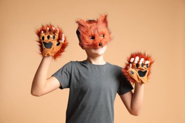 Quadrobics. Boy wearing fox mask and gloves on beige background clipart