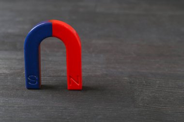 Siyah ahşap masa üzerinde bir at nalı mıknatısı, metin için boşluk