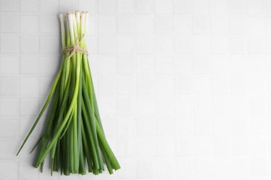 Beyaz fayanslı masada taze taze soğan, üst manzara. Metin için boşluk