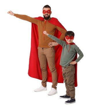 Baba ve oğlu beyaz arka planda süper kahraman kostümleri giyiyorlar.