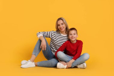 Mutlu anne ve oğlu turuncu zemin üzerine